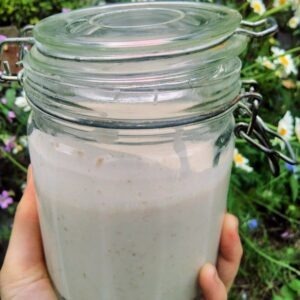 a jar fo sourdough starter and soem flowers