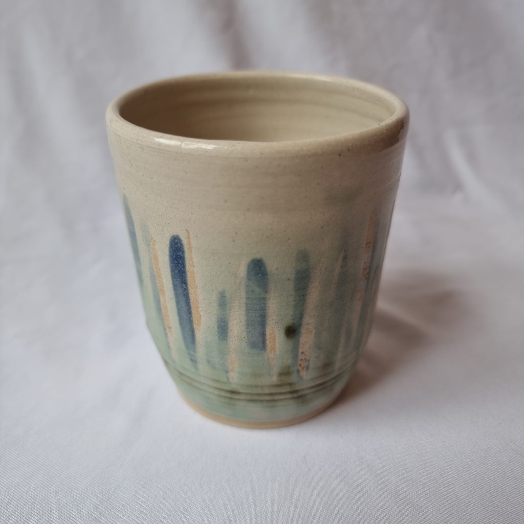 greeny white beaker with pale blue vertical stripes
