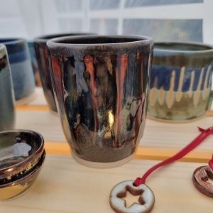 ceramic beaker and mugs and christmas decoration on wooden crate