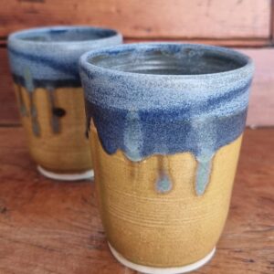 2 blue and yellow beaker on wooden background